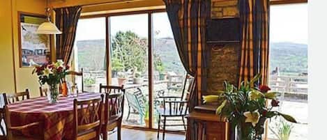 Un comedor con una mesa para dos, una chimenea y vistas al exterior.