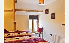 A bedroom with a bed, a chair, a window, and artwork on the wall. - Peacock Cottage, Pet Friendly,  Black Mountain Range, nestled on Brecon Beacons (Brecon)