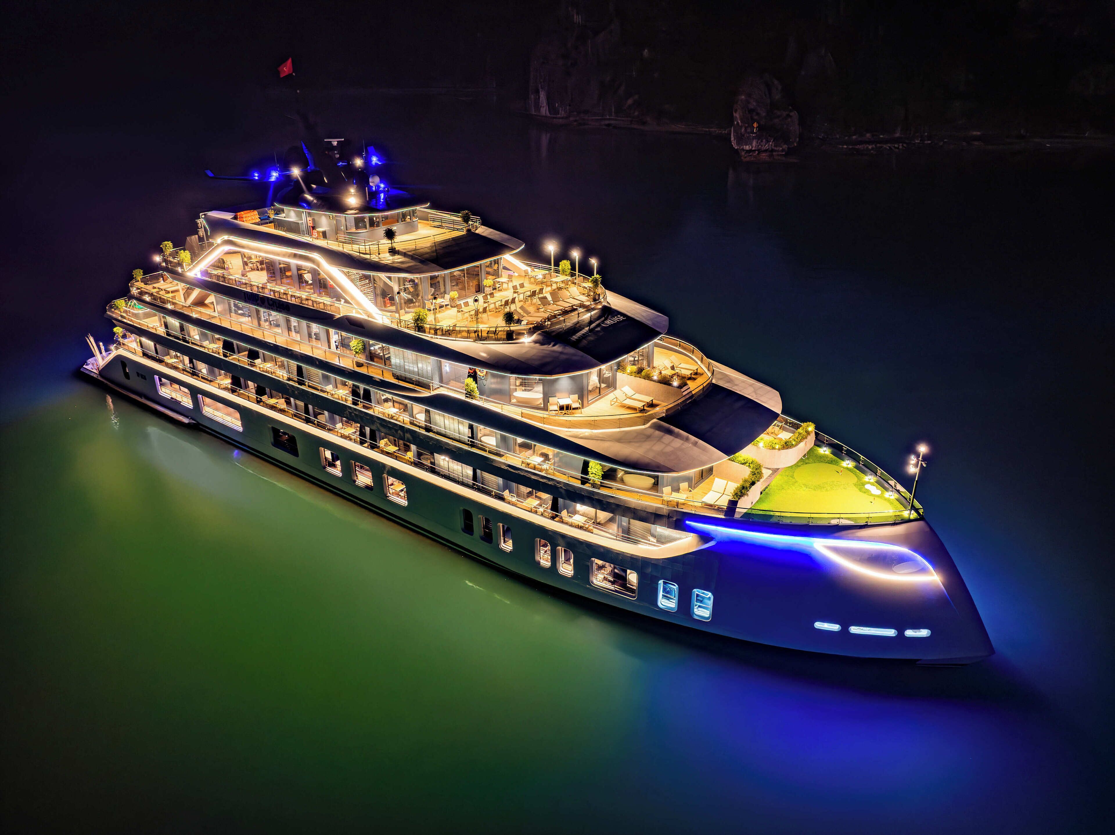 A multi-deck cruise ship with outdoor seating areas and a helipad.
