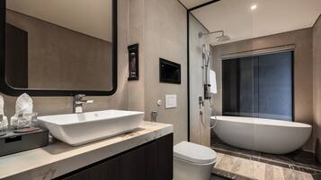 Een aparte badkuip en douche, een regendouche, gratis toiletartikelen