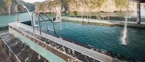 Una piscina al aire libre, sombrillas, guardavidas en la propiedad