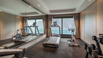 Une salle de sport équipée de machines de cardio, de machines de musculation et d’haltères.
