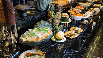 A buffet with various food items and a decorative vase.