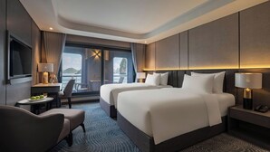 Una habitación de hotel moderna con dos camas, un escritorio, una silla y un televisor.