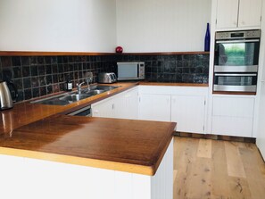 Equipped with a microwave, toaster, and kettle, this kitchen offers a convenient cooking space.