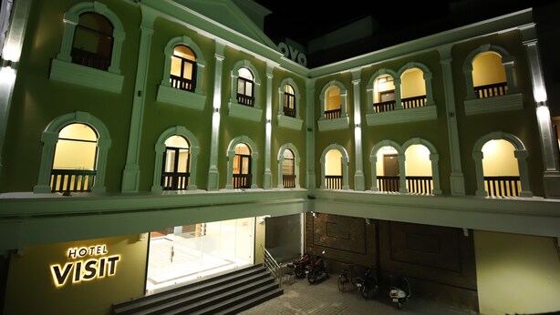 A multi-story hotel with a central courtyard, balconies, and a sign reading "HOTEL VISIT". - Hotel Visit (Barnala)
