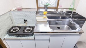 A compact kitchen with a gas stove, a sink, and a window. - Centrally Located Deluxe Furnished.4 (Tokyo)