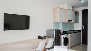 Eine moderne Küche mit integriertem Waschmaschine, einem Flachbildfernseher und einem Essbereich mit Tisch und Stühlen.
