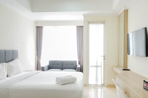Relax in a spacious room with a large bed, flat-screen TV, and a console table.