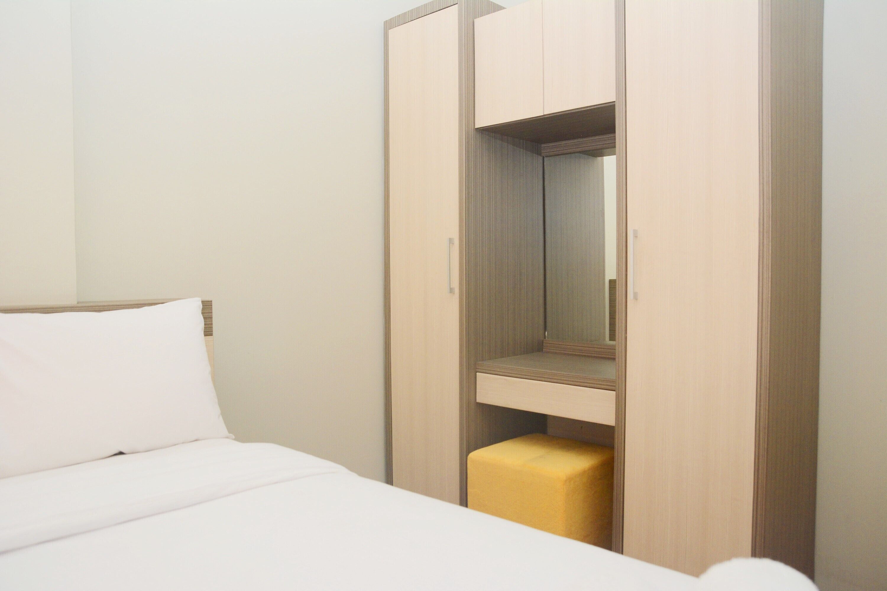 Ein Hotelzimmer mit Bett, Kleiderschrank und Spiegel.