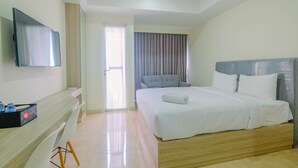 Une chambre d’hôtel équipée d’un lit, d’un bureau, d’une chaise, d’une télévision et d’une fenêtre avec des rideaux.
