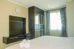 Relax in a stylish room with a large bed, flat-screen TV, and wardrobe.