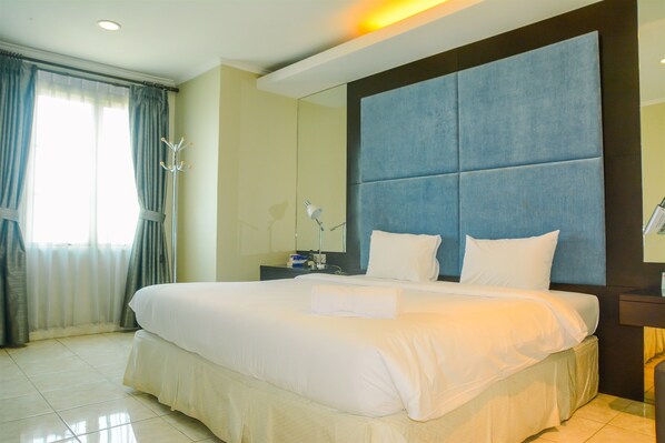 Relax in a stylishly designed room with a large bed, nightstand, and lamp.
