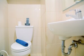Bathroom features a toilet, sink, and chrome faucet.