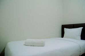 Rest on a comfortable bed with a neatly folded towel at the footboard.