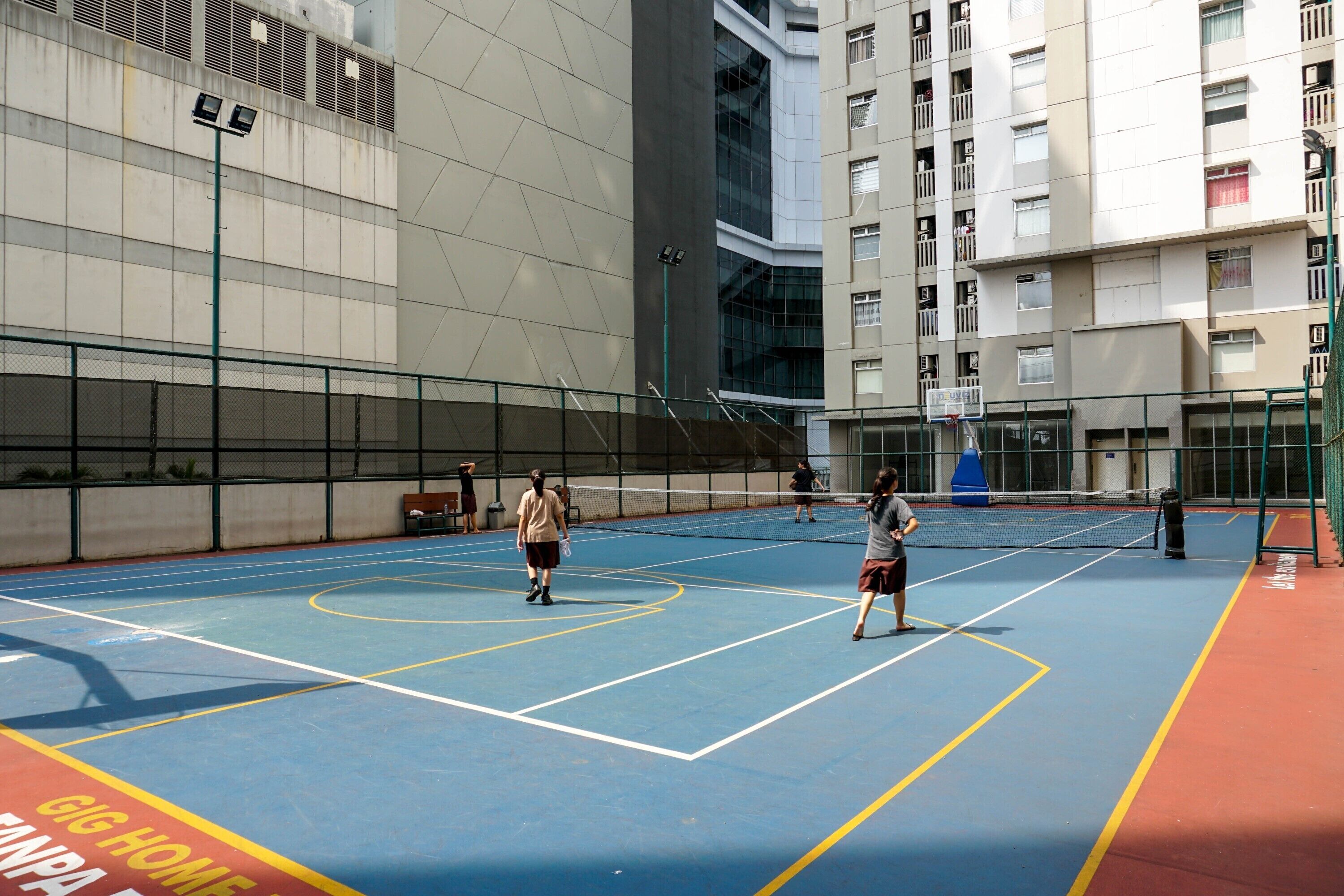 Un court de tennis intérieur doté d’une surface de jeu bleue et de lignes de démarcation jaunes.