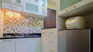 Una cocina con armarios blancos, un salpicadero a cuadros, un refrigerador Panasonic y un horno empotrado.