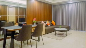 A modern living room with a sofa, coffee table, and dining area.