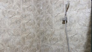 Ein Badezimmer mit Dusche und Fliesen.