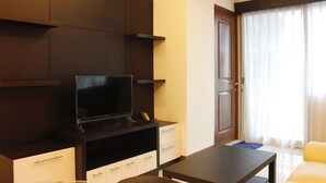 Ein modernes Wohnzimmer mit Flachbildfernseher, Couchtisch und Sofa.