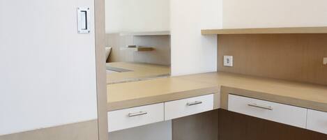 A compact kitchen with a countertop, two drawers, and a cabinet.