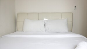 A neatly made bed with a white headboard and pillows, a white blanket, and a rolled white towel on the side. - Compact 2BR @ Galeri Ciumbuleuit 2 Apartment near Dago (Bandung)