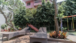 A patio area with lounge chairs, a slide, and potted plants. - Affordable Studio Galeri Ciumbuleuit 2 Apartment near Dago (Bandung)