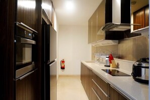 Room | Private kitchen | Fridge, microwave, stovetop, electric kettle - Spectacular 3BR Apartment at The Peak Residence (Surabaya)