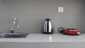 Kamer | Privékitchenette | Een koelkast, een kookplaat, kookgerei, borden en bestek