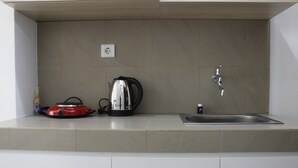 Eine Küche mit Spüle, Wasserkocher und einem roten Gerät auf der Arbeitsfläche.
