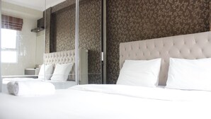 A hotel room with a large bed, a glass shower enclosure, and a patterned wallpaper. - Elegant 2BR Gateway Pasteur Apartment near Exit Toll Pasteur (Cimahi)