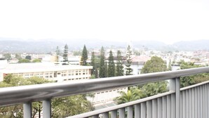 A balcony with a metal railing overlooking a cityscape with buildings and trees. - Trendy 1BR near ITB @ Dago Suites Apartment (Bandung)