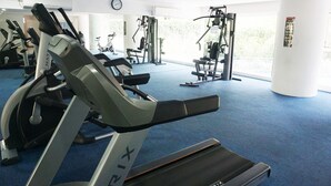 A gym with treadmills, weight machines, and a blue carpeted floor. - Trendy 1BR near ITB @ Dago Suites Apartment (Bandung)