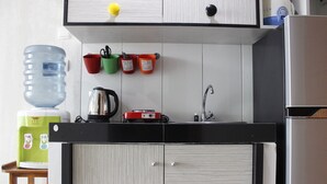 A kitchen with a water dispenser, a kettle, and a coffee maker on the counter. - Trendy 1BR near ITB @ Dago Suites Apartment (Bandung)