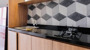 Una cucina moderna con un piano di lavoro nero, un fornello a gas e un lavello.