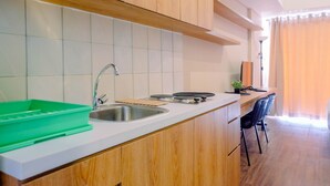 A modern kitchen with a sink, stove, and wooden cabinets.