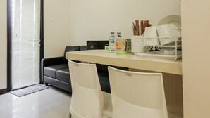 Una cocina pequeña y moderna con sillas blancas, una mesa de comedor y un lavavajillas integrado.
