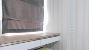Une chambre moderne avec un banc intégré et une fenêtre équipée d’un store.