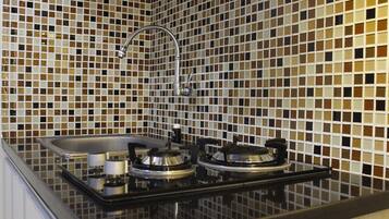 Kamer | Privékeuken | Een koelkast, een kookplaat, kookgerei, borden en bestek