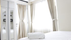 Une chambre d’hôtel avec un grand lit, une armoire et des rideaux.