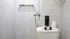 Une salle de bain moderne équipée d’une douche, de toilettes et d’articles de toilette.
