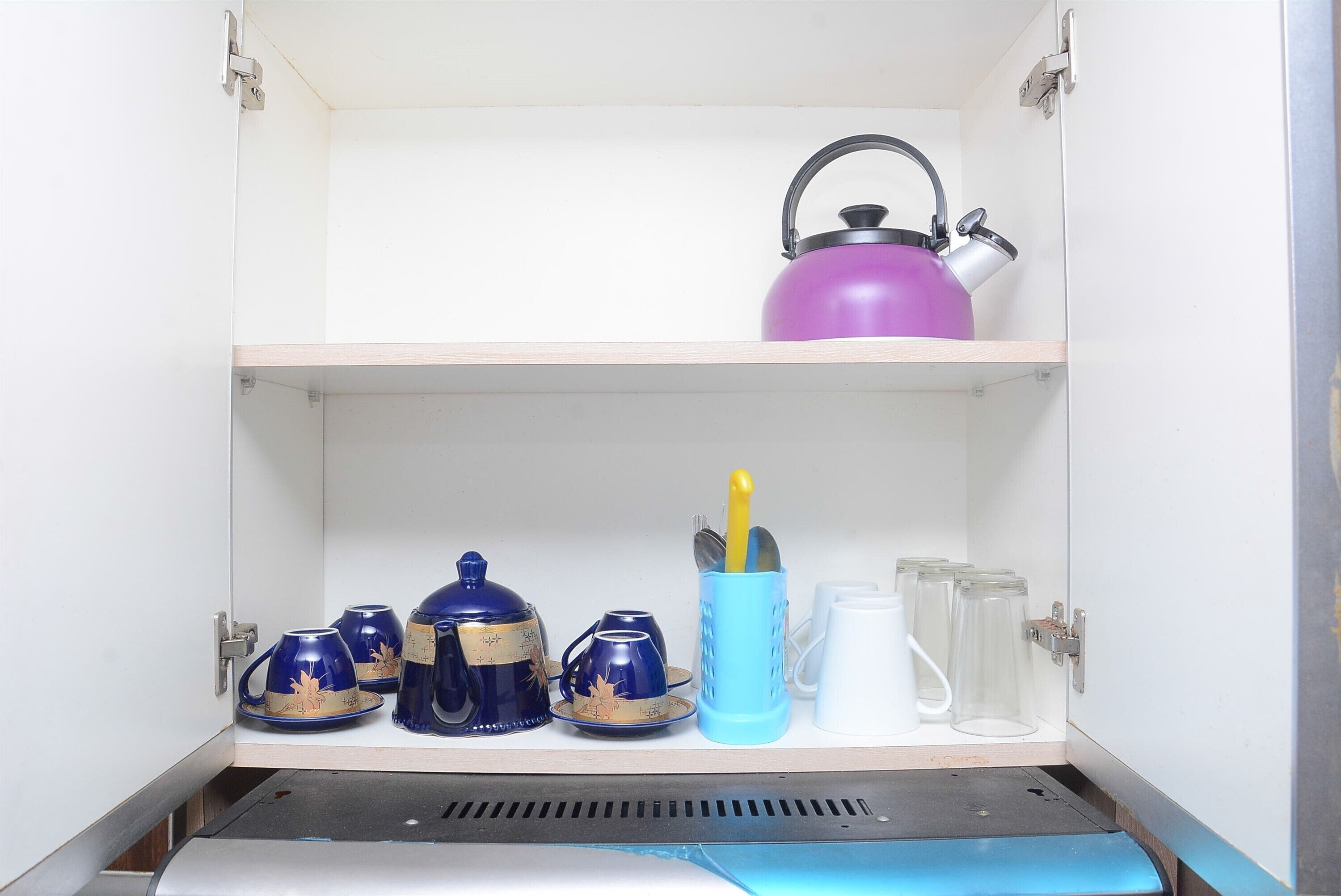 Armário de cozinha com prateleiras contendo utensílios.