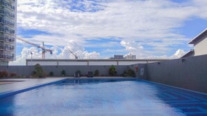 A swimming pool with a view of a construction crane and buildings in the background. - 2BR Apartment at Park View Condominium near Universitas Indonesia (Depok)