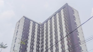 A multi-story building with a prominent "DAVE" sign on the side. - Stylish and Convenient Studio Dave Apartment (Depok)