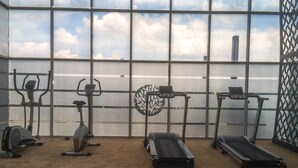 Une salle de sport équipée de vélos d’appartement, d’un appareil elliptique et de tapis de course.