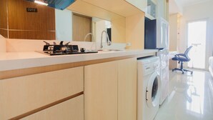 Une cuisine moderne équipée d’un lave-linge, d’un four à micro-ondes et d’un évier.