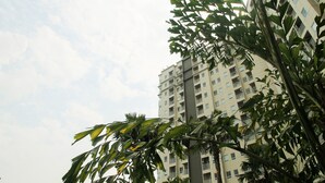 Um edifício com várias andares, varandas e céu claro.