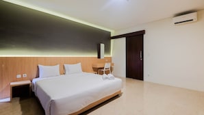 Moderni hotellihuone, jossa on suuri sänky, työpöytä ja tuoli.