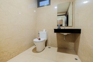 A bathroom with a toilet, sink, and mirror. - 1BR Pancoran L'Avenue Comfy Apartment (Jakarta)