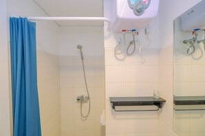 A bathroom with a shower, a toilet, and a sink. - Comfortable Studio Apartment at Woodland Park Residence (Jakarta)